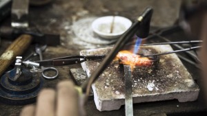 Goudsmid soldeert in het atelier